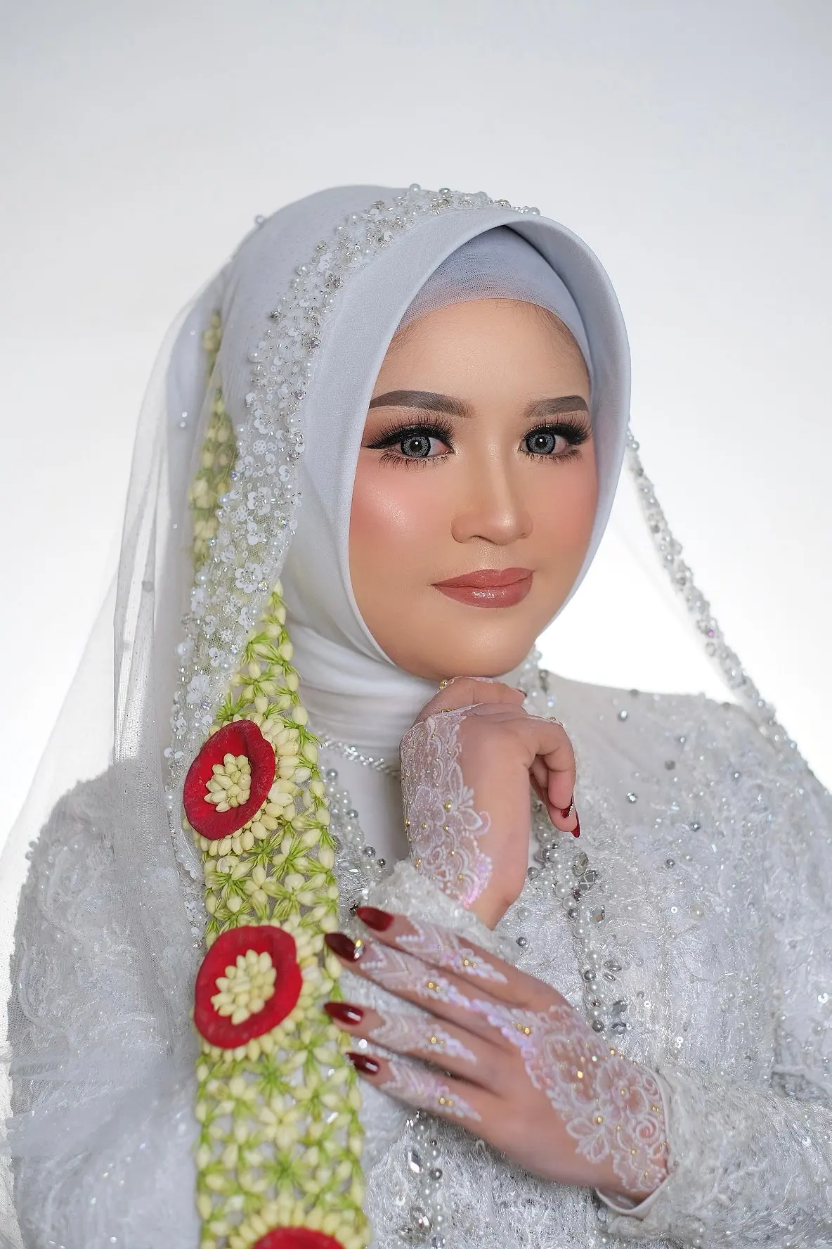 Pengantin berhijab abu muda dengan kerudung renda, ronce melati dan mawar merah