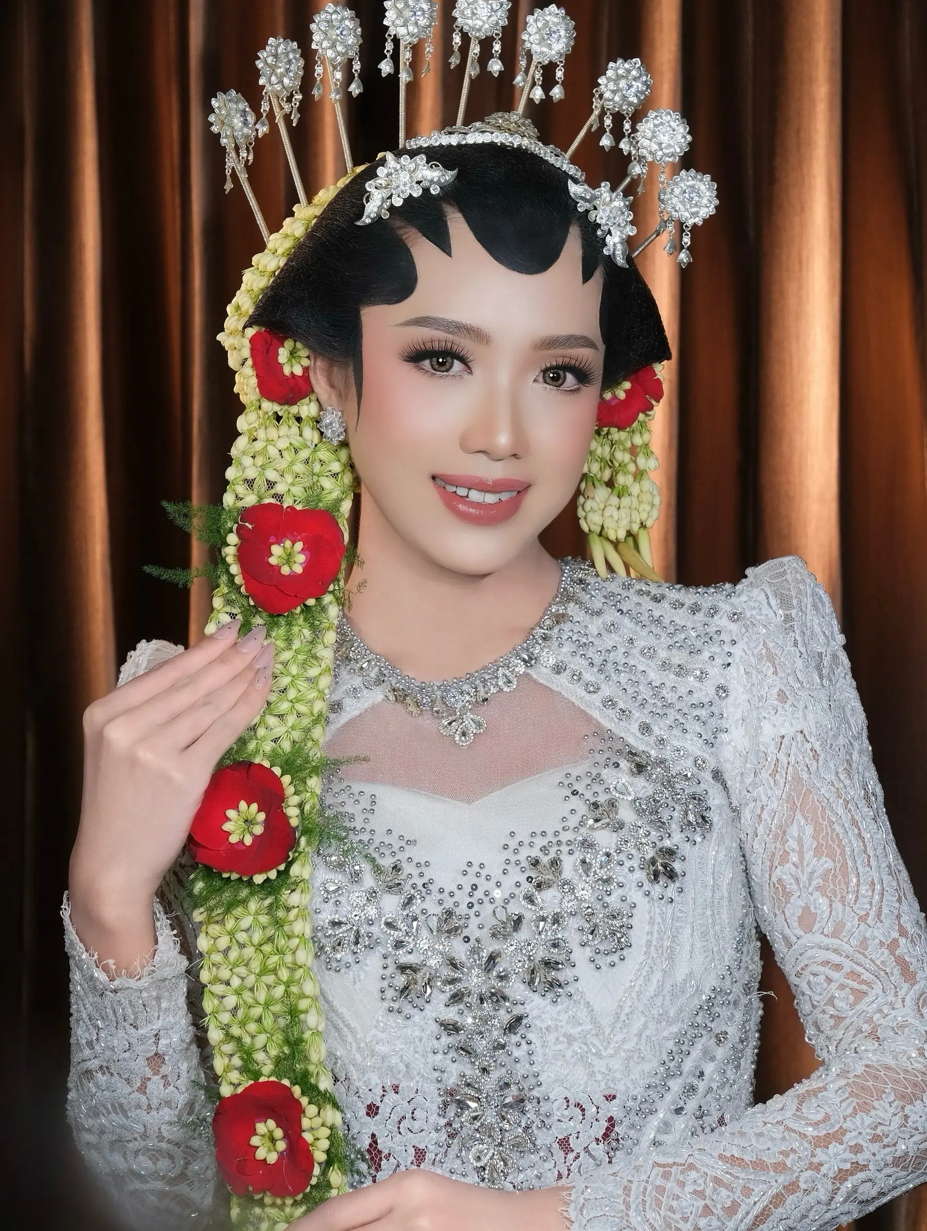 Pengantin paes Solo dengan cunduk mentul, ronce melati dan mawar merah, memakai kebaya payet perak